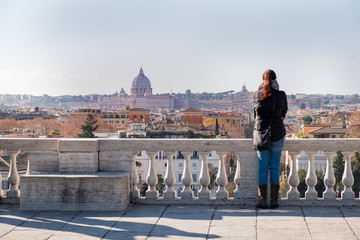 A girl admires the view of the city of Roma from above, from the hill of Terrazza del Pincio. Italy 
 - obrazy, fototapety, plakaty