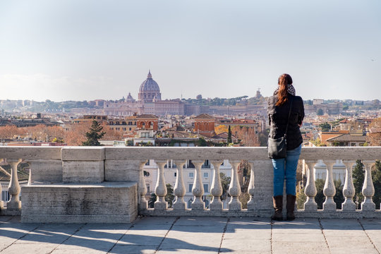 A girl admires the view of the city of Roma from above, from the hill of Terrazza del Pincio. Italy 
