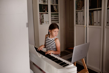 Remote music lesson, child playing digital piano