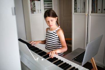 Remote music lesson, child playing digital piano
