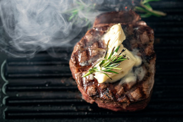 A steaming beef tenderloin steak is grilled in a grill pan with the text copy space. The concept of...