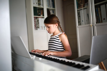Remote music lesson, child playing digital piano