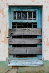 Window clogged with old boards. Abandoned house.