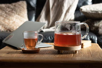 jarra y taza de te con ordenador portátil 