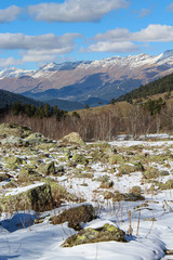 Snow-capped mountain peaks and stones with moss. Arkhyz