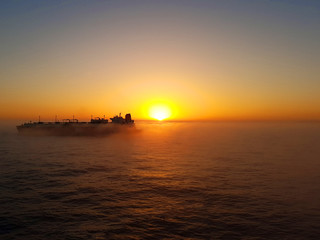 Fototapeta na wymiar Mist covering ship tanker at dawn