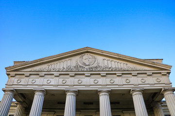Old Soviet building with columns against the blue sky.