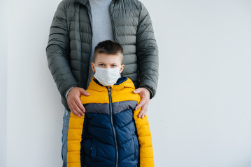 A father with his child stands in a mask during the quarantine. Pandemic, coronavirus