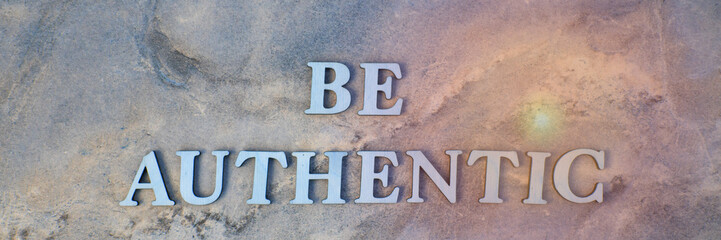 be authentic , writen wooden letters on stone background