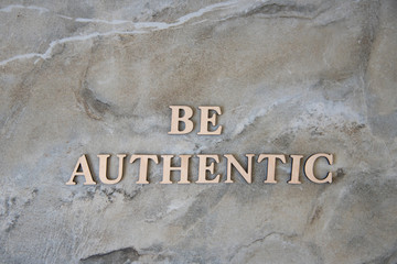 be authentic , writen wooden letters on stone background