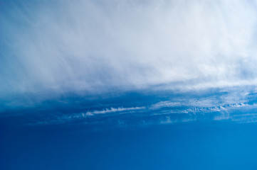 Fototapeta premium Contrast of smooth blue saturated sky and soft loose white clouds. Sky photo