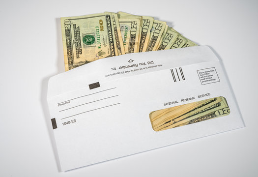 Stack Of 20 Dollar Bills In IRS Envelope To Illustrate Coronavirus Stimulus Payment Or Estimated Tax Payments On White Background