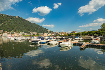 Fototapeta na wymiar Como, ITALY - August 4, 2019: Marina in the Lake Como in the center of beautiful Italian Como city. Warm sunny summer day in very popular holiday destination