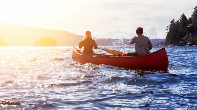 Cinemagraph Continuous Loop Animation. Couple friends on a wooden canoe are paddling in water during a vibrant sunny day. Taken in Indian Arm, near Deep Cove, Vancouver, British Columbia, Canada.