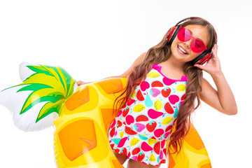 sweet girl about to swim in the sea with a rubber ring and a mattress on an isolated white...