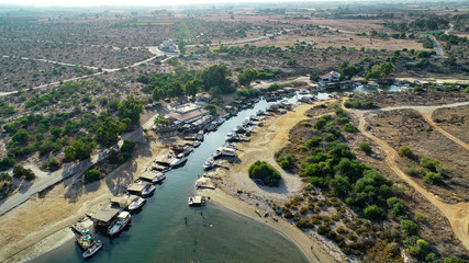 Aerial bird's eye view Liopetri river to sea (potamos Liopetriou), Famagusta, Cyprus.Fjord landmark tourist attraction fishing village with colourful boats moored on banks at Kokkinochoria, from above