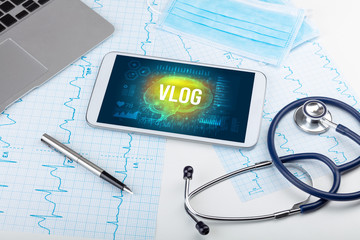Tablet pc and medical tools with VLOG inscription, social distancing concept