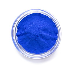 Blue powder paint in glass bowl, top view