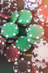 Gambling poker chips on green play field for luck game. Poker chance or risk.