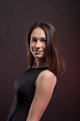 Cute smile of pretty young girl in the darkness. Elegant black dress, so dark everywhere. Amazing girl with attractive appearance