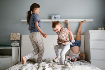 Funny crazy Three children jump on big bed in room