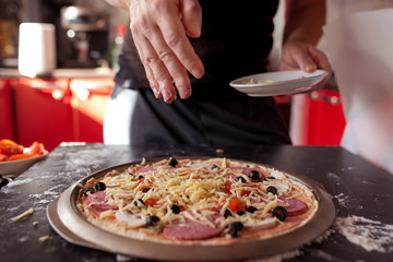 Making pizza at home. Fresh original Italian raw pizza, preparation in traditional style.