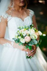 Naklejka premium Bride holds a wedding bouquet, wedding dress, wedding details