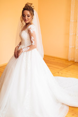 Fototapeta premium bride in white dress posing while preparing for the wedding ceremony