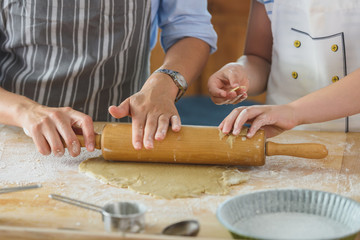 Mother and daughter making apple pie in the kitchen. Teaching child to help at home