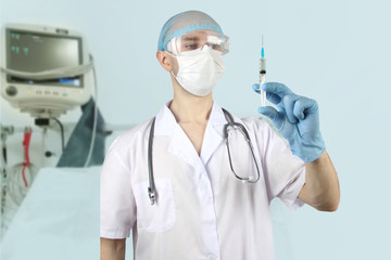 male doctor in defocus with a stethoscope holds a syringe in his hand against the background of a...