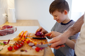Isolation With Fun. Happy Father And His Little son cooking in Kitchen, Staying At Home During Quarantine