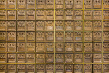 A wall of old PO post office mail boxes
