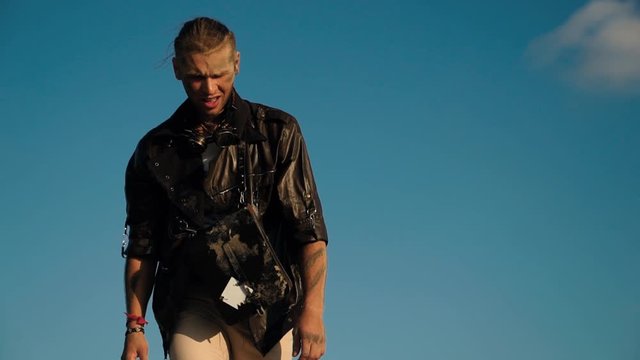 a lone wandering man survivor rises on desert hill after apocalypse and looks into the distance. Forsaken men with hopes seeking for salvation concept