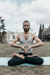 Fototapeta na wymiar young man with ponytail doing yoga in a park
