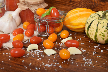cocktail tomatoes, garlic, spices, colorful pumpkins and scattered kitchen salt
