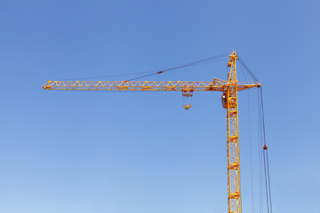 Yellow Construction Tower Crane Against Blue Sky