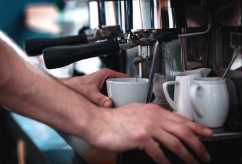 Fototapeta na wymiar Close up of barista hands preparing cappuccino in cafe shop.