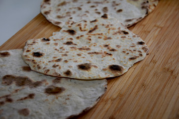 baked cake with spices in the shape of a circle on a hot pan for homemade baking flat bread