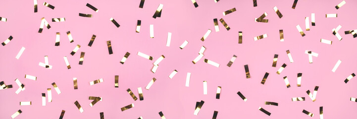 Gold confetti on pink background. Flat lay, top view.