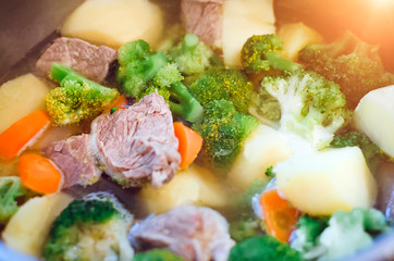 Cooking at home - beef meat with potatoes and broccoli. Closeup, selective focus.