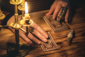 Fortune teller is reading a future by tarot cards close up.