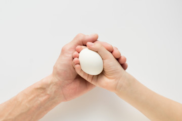 Fototapeta na wymiar Hand of a child and an adult holding an egg