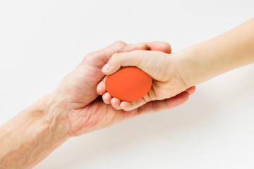 Hand of a child and an adult holding an Easter egg