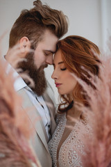 close portrait of a red-haired girl and a bearded guy