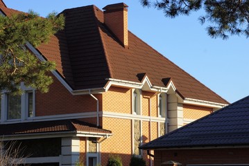 Obraz premium part of a large private house with windows under a brown tiled roof 