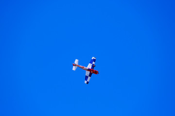 airplane model performs aerobatics in the sky, plane model against blue sky
