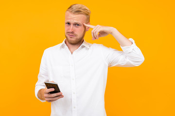 guy in a white t-shirt with a cell phone in his hand