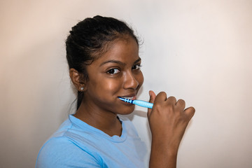 Happy young woman brushing teeth