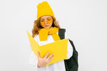 teenager girl with books in hand and a backpack on his shoulders on a white isolated background