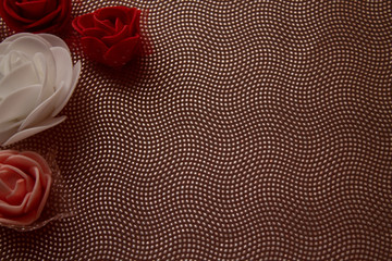 colored roses in a corner on a pink textured background